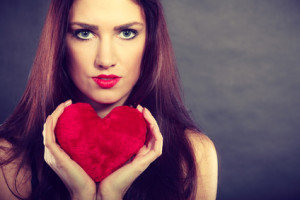 Woman holds red heart love symbol