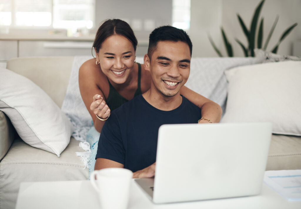 pareja sonriendo y mirando al ordenador