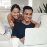 pareja sonriendo y mirando al ordenador