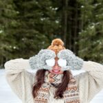 retrato invernal de una joven sosteniendo bolas de nieve
